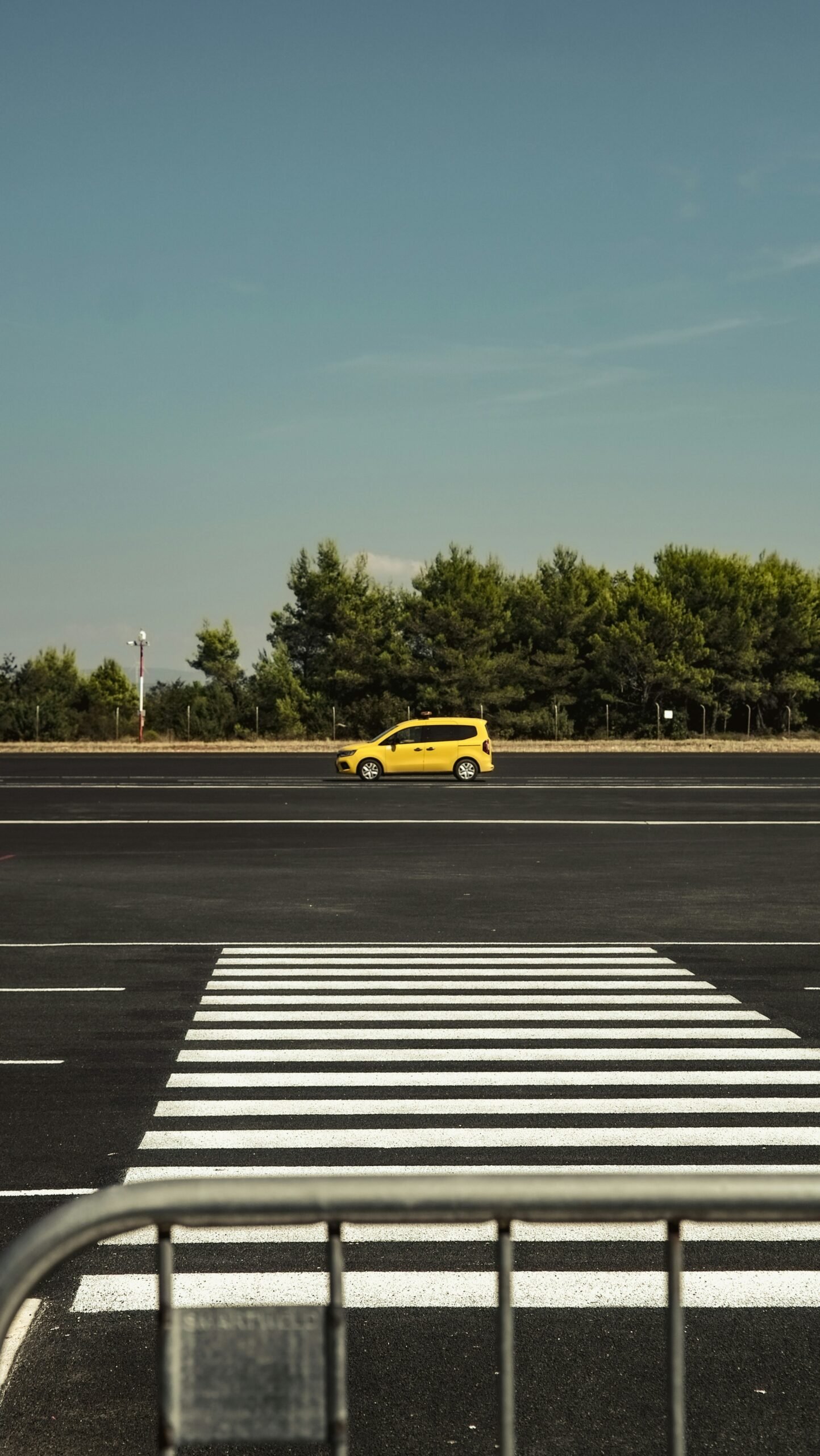 A yellow car is parked in a parking lot